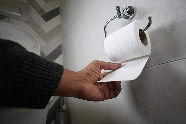 istock Hand reaching for toilet paper in modern bathroom setting 2233555751