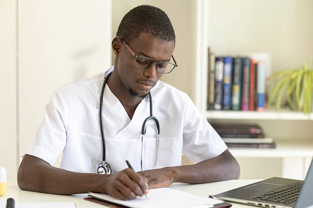 istock Focused doctor taking notes during consultation in medical office 2233563868