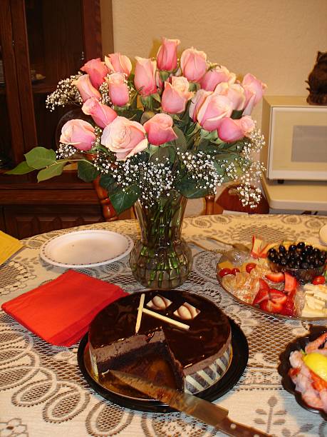 Pink roses beside the chocolate cake celebrating a Birthday.