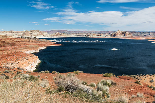 View of Navajo Mountain overlooking Lake Powell, with deep blue water and dramatic desert cliffs under a cloudy sky. Perfect for travel, adventure, and landscape photography themes.