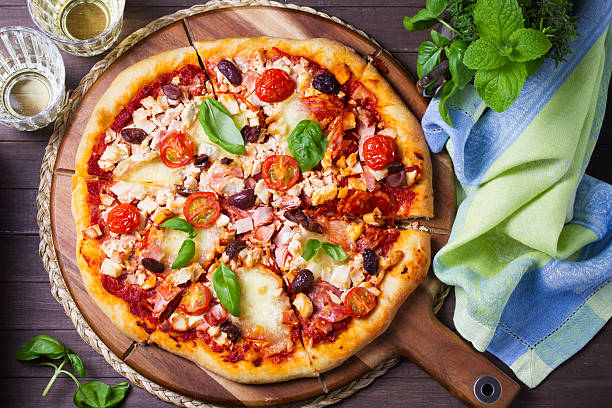 istock Delicious pizza served on wooden pizza board 2233574168