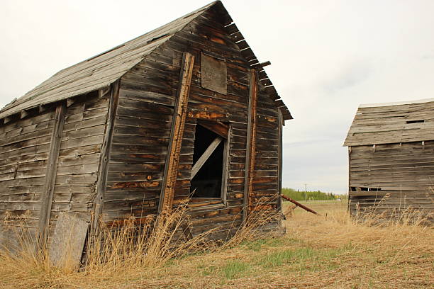 Old wooden plank barn with very worn red paint with hay loft in Montana in USA and North America.
