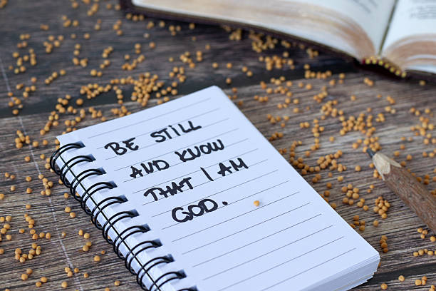 istock Be still and know that I am God, inspirational quote in notebook with mustard seeds 2233579017