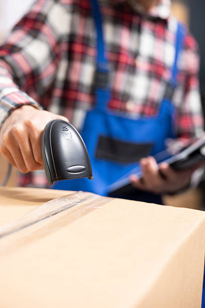 istock Small business employees labeling parcels in packaging station 2233579364