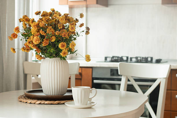 istock Cozy Kitchen Table with Flowers and Coffee Cup 2233579656