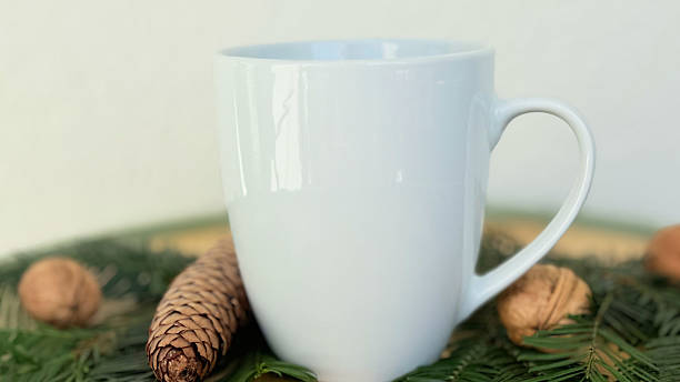 istock Close Up White Mug With Pine Cones and Walnuts on Evergreen Branches — Cozy Winter Decoration, Minimal Mockup with Copy Space for Banner, Branding and Template Design 2233580696