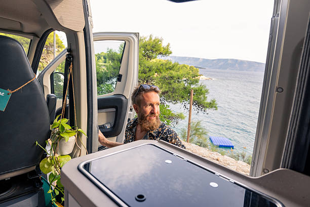 istock Man Enjoying Coastal View from Camper Van Door 2233583881