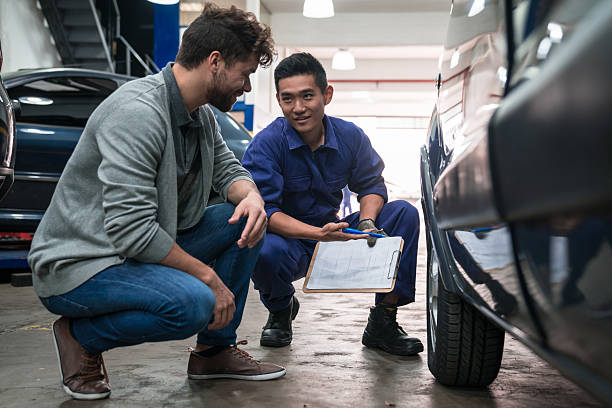 istock Car mechanic checking wheel in garage 2233585847