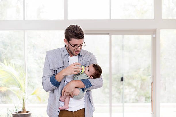 istock Father Gently Feeds His Infant Son a Bottle at Home 2233586129