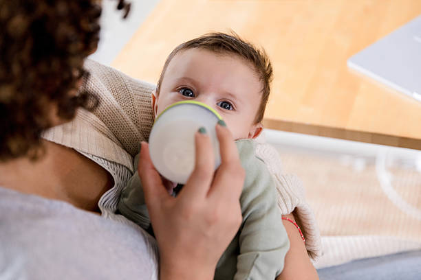 istock Mother Gently Feeds Her Baby Milk From Bottle 2233586142