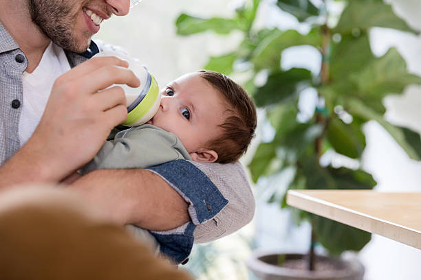 istock Happy Father Feeding His Baby Boy with Bottle 2233586143