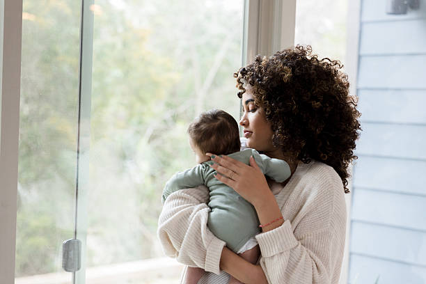 istock Mother Holding Baby, Looking Out Window, Peaceful Moment 2233586149