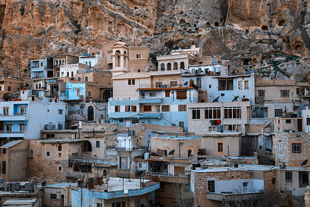 Maaloula, a picturesque village in Syria, clings to the cliffs, showcasing traditional architecture against a dramatic backdrop of rock formations