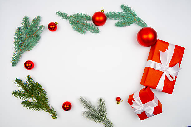 istock Christmas flatlay with fir branches red baubles and gift boxes forming round frame on white background with copy space perfect for holiday card winter banner greeting template or online shop design 2233589467