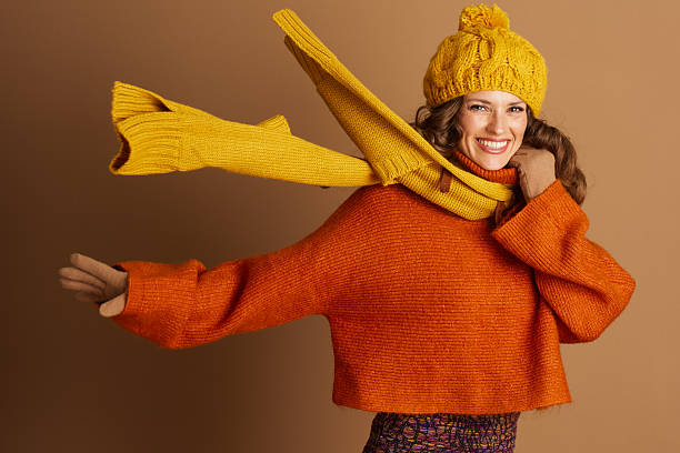 Playful Woman in Autumn Sweater and Yellow Beanie Pose stock photo