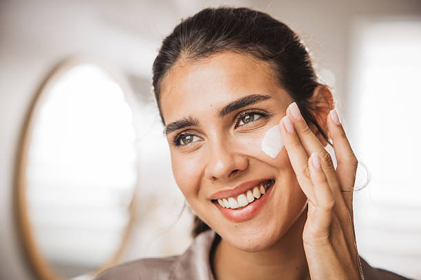 istock Young woman applying moisturizing cream 2233589972