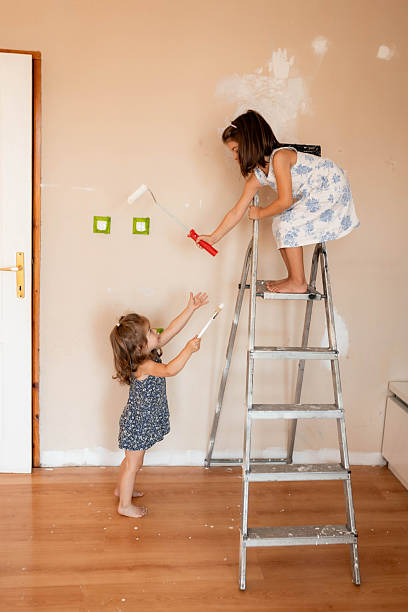 istock Sisters Painting Wall Together During Home Renovation 2233590061