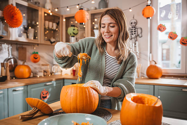 istock Woman carving pumpkin for Halloween 2233590209