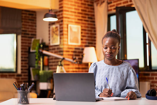 istock Businesswoman comparing data on laptop and notepad 2233590317