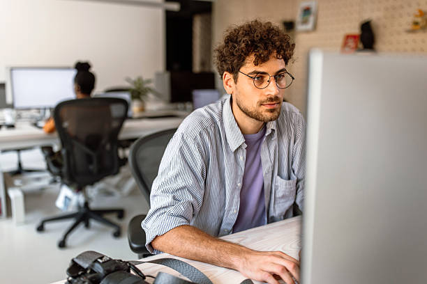 istock Young businessman working on desktop pc in the office 2233593030