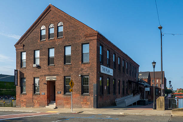 Holyoke, MA - US - Aug 24, 2025 A historic brick building marked MAUREAN 1873 stands under a clear blue sky, featuring arched windows and classic architectural symmetry.