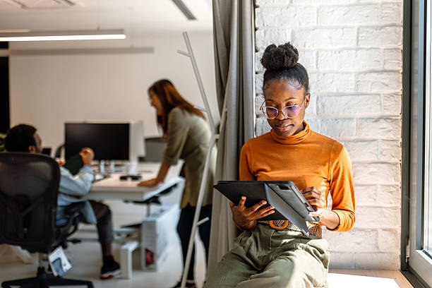 istock Young beautiful black woman working using digital tablet in the modern office 2233593172