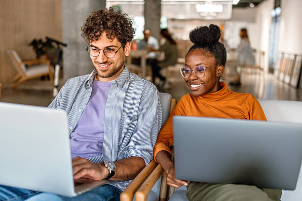 istock Two coworkers working on laptops at modern company caffe. 2233594074