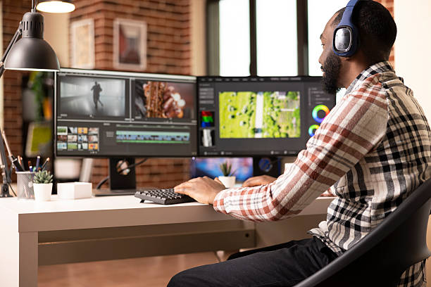 istock Creative man with headphones editing videos on computer 2233594837