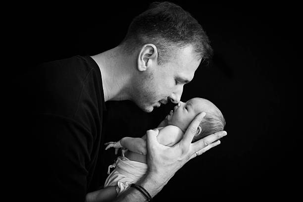 istock Newborn baby sleeping in her father's arms 2233595731
