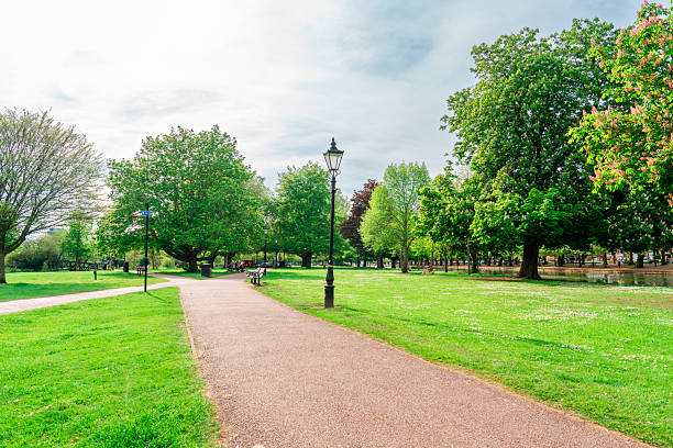 istock Bedford park path leading through lush green grass in summer 2233597158