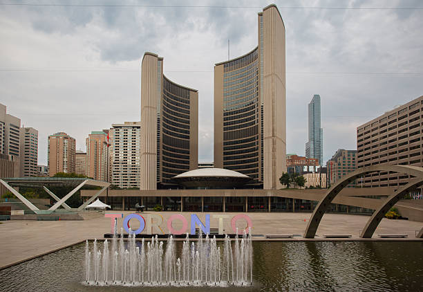 Tall clock tower of Toronto City Hall against a backdrop of sunset clouds
