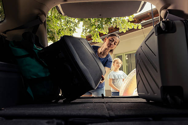 istock Small family of two share cheerful moment loading the car trunk with essentials 2233598743
