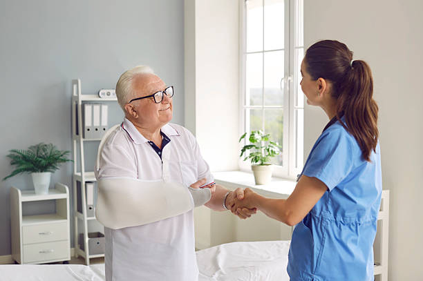 istock Happy patient with broken arm shaking hands with doctor, thanking for help and smiling 2233598906
