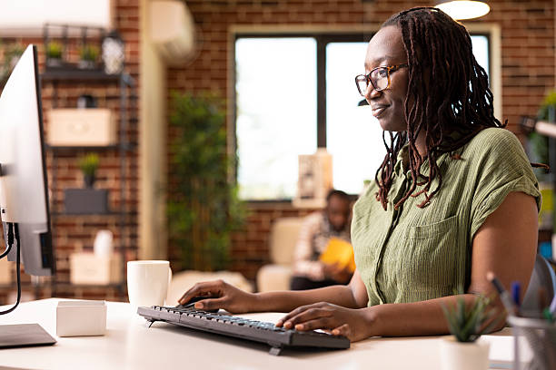 istock Happy african american woman working indoors on computer 2233600301