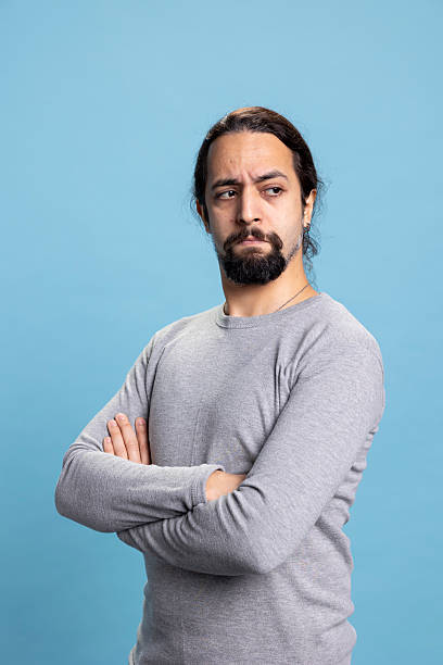 istock Confident person with a beard and curly hair posing in studio 2233600393