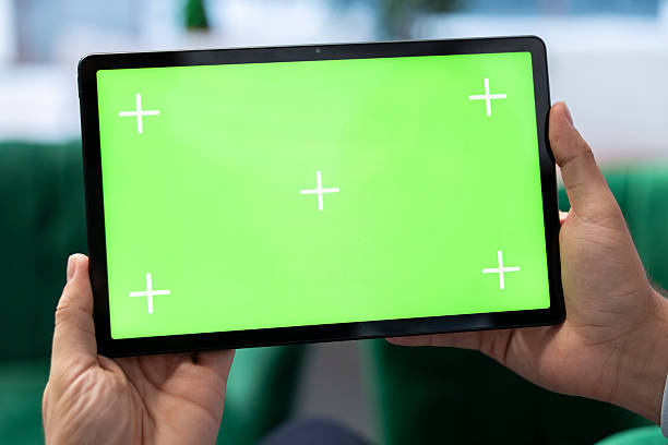 istock Businessman in a luxurious office looks at green screen on tablet 2233603880