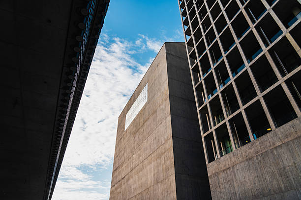 istock Modern concrete buildings reaching for a cloudy blue sky 2233603899