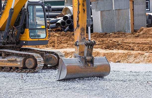 istock An excavator on a construction site in close-up. The excavator rams the crushed stone with a bucket for construction. Heavy machinery for construction and landscaping. 2233604120