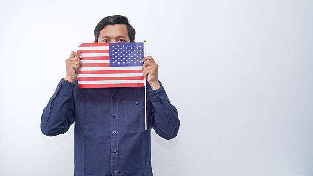 istock Asian Man holding USA flag at studio against white background 2233608518