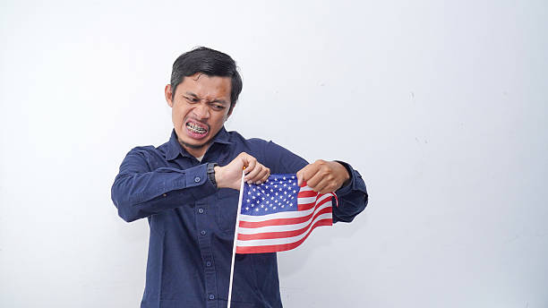 istock Man holding USA flag at studio against white background 2233608527