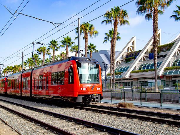 istock Modern Urban Red Tram Passing Through Cityscape with Palm Trees 2233608566