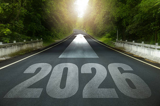 istock Long forest road with 2026 painted on asphalt and a forward arrow into sunlight, symbolizing New Year goals, business and life direction, roadmap, strategy, motivation, progress and success. 2233610931