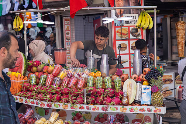 Istanbul, Trukey - July 3, 2023: Grand Bazaar or Egyptian spice market in Istanbul. A man are making fruit juice.