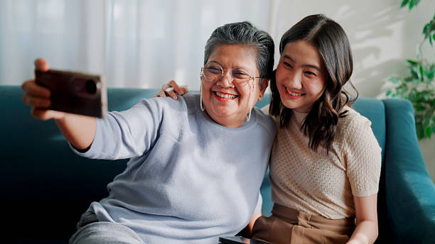 istock Asian mother and daughter taking selfies while spending time at home together. 2233618544
