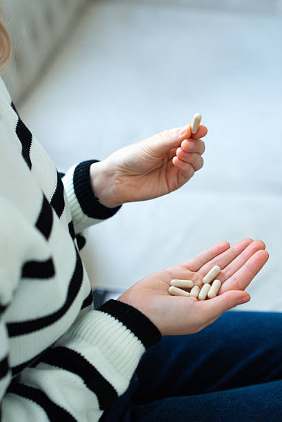 istock Female hand holding pills 2233619840