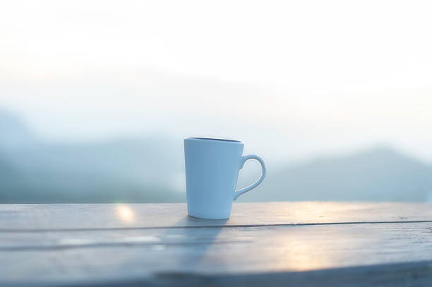 Cup of coffee on wooden table at sunset, sunset nature background nature concept.