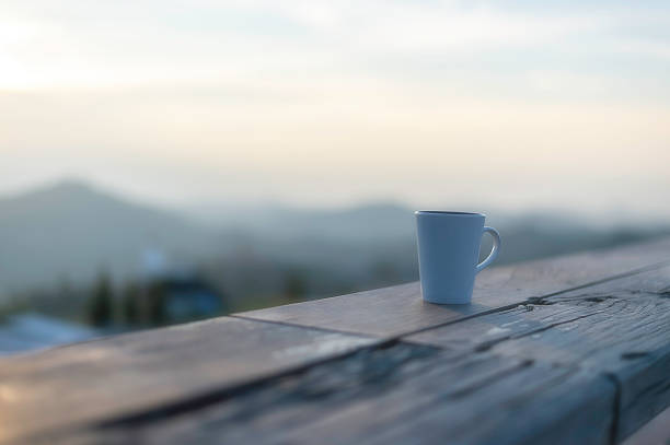 Cup of coffee on wooden table at sunset, sunset nature background nature concept.