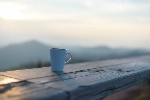 Cup of coffee on wooden table at sunset, sunset nature background nature concept.