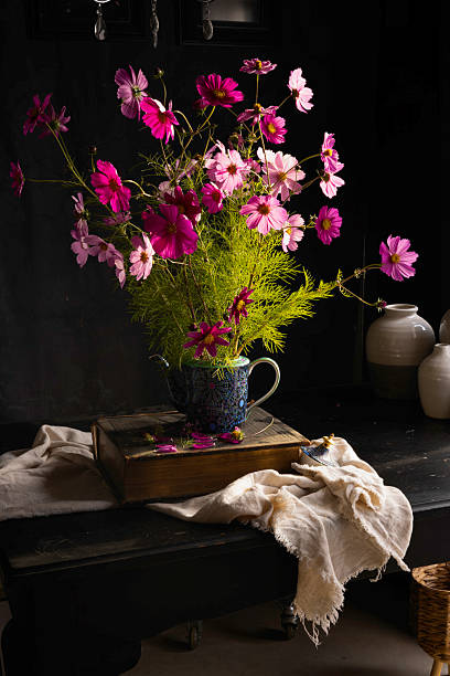 istock Cosmos flowers in ornate vase on a black table 2233620963