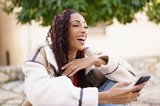 istock A Joyful Woman is Using Her Smartphone Outdoors while Experiencing Genuine Laughter and Relaxation 2233630325